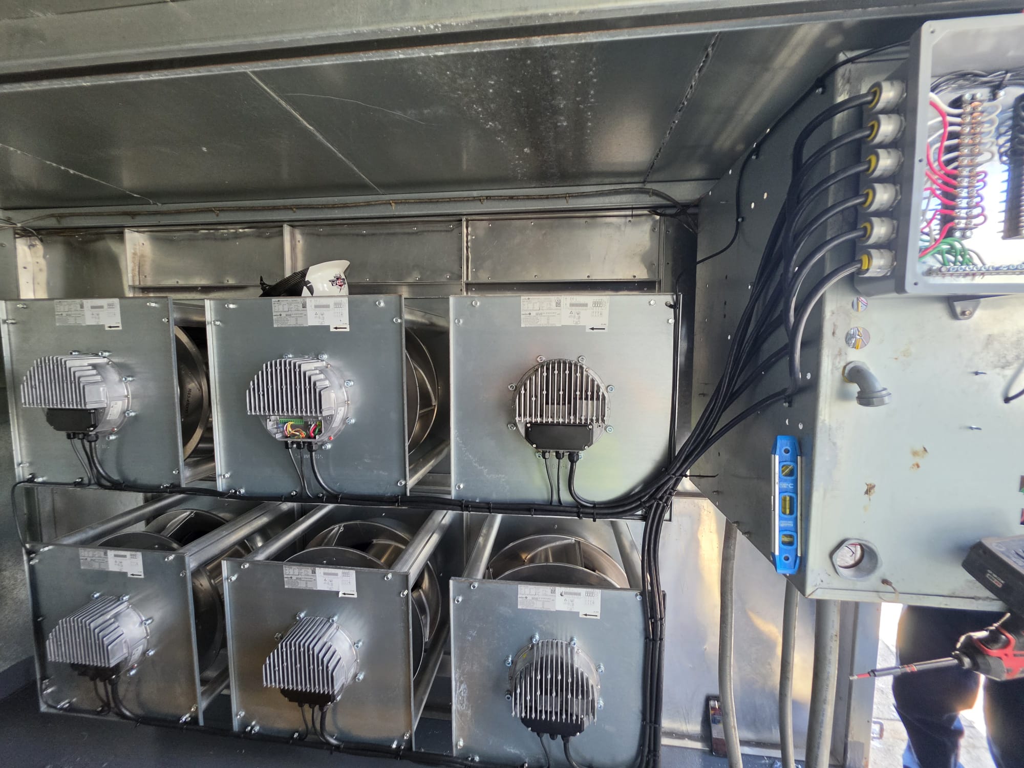 Rear view of six EC plug fans with power and control wiring routed to a junction box