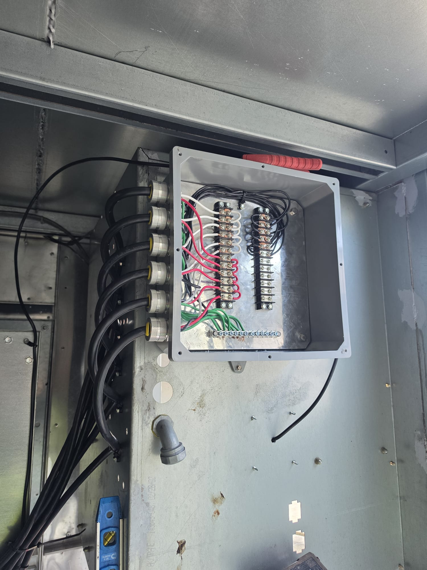 Open junction box showing terminal blocks for EC plug-fan power and control wiring